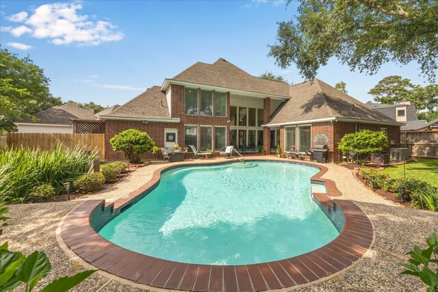 311 Pineview Cir, El Lago, TX 77586 - view of swimming pool with a fenced backyard, central AC unit, a patio, and a sunroom