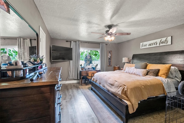 bedroom featuring wood finished floors, a textured ceiling, and ceiling fan