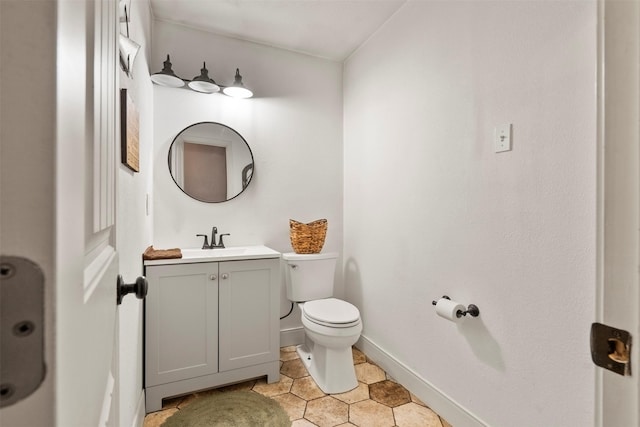 bathroom featuring toilet, baseboards, vanity, and tile patterned flooring