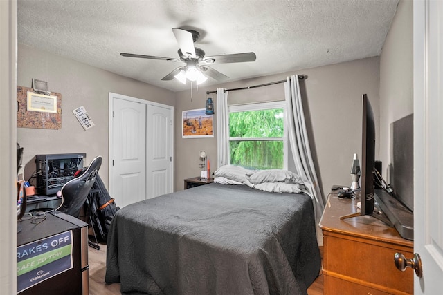 bedroom with a closet, a textured ceiling, ceiling fan, and a desk
