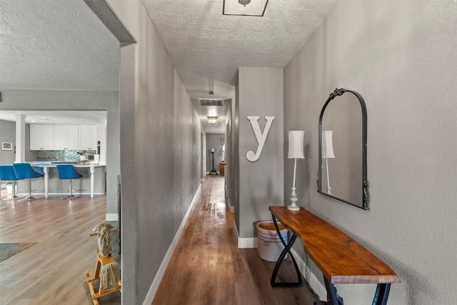 5211 Ghinaudo Rd, Hitchcock, TX 77563 - hallway with wood finished floors and a textured ceiling