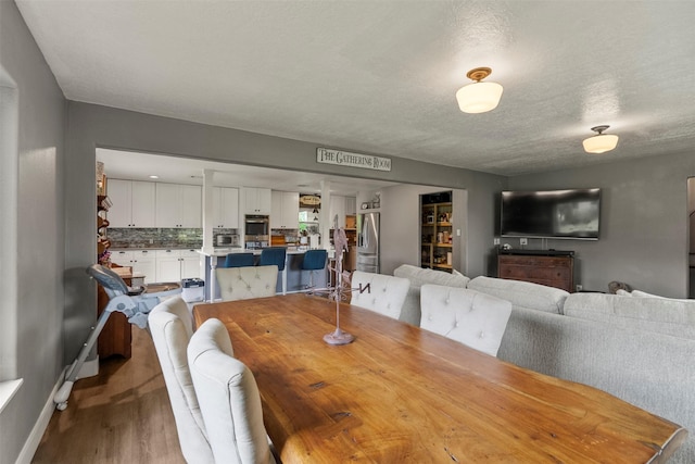 dining space featuring wood finished floors and a textured ceiling