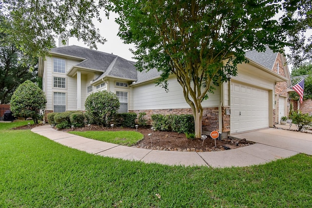 7218 Welshwood Ln, Sugar Land, TX 77479 - view of front of house with a front lawn, concrete driveway, an attached garage, roof with shingles, and stone siding