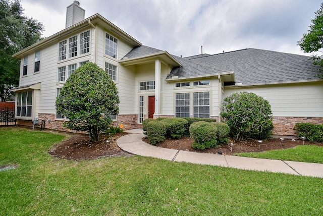 7218 Welshwood Ln, Sugar Land, TX 77479 - view of front facade featuring a chimney, a front lawn, and stone siding