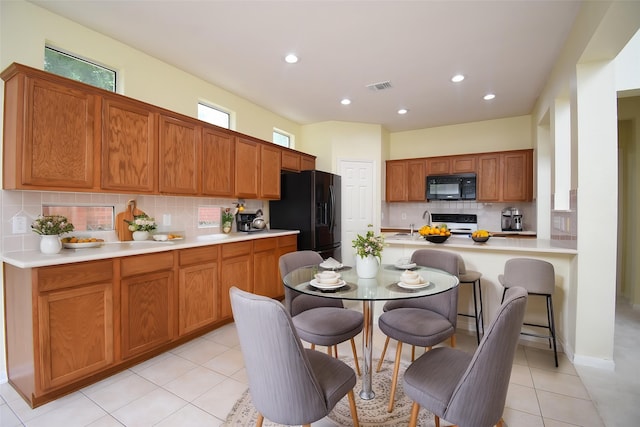 7218 Welshwood Ln, Sugar Land, TX 77479 - kitchen featuring black appliances, decorative backsplash, light countertops, light tile patterned floors, and recessed lighting