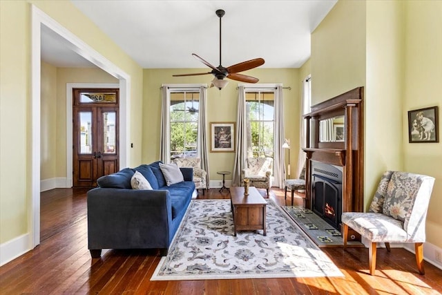 1427 Winnie St, Galveston, TX 77550 - living area featuring dark wood-type flooring, baseboards, a ceiling fan, and a lit fireplace