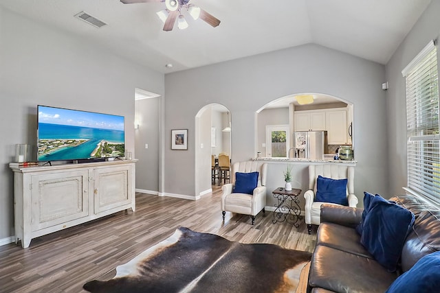 4418 Legends Bay Dr, Baytown, TX 77523 - living room featuring arched walkways, ceiling fan, wood finished floors, plenty of natural light, and vaulted ceiling