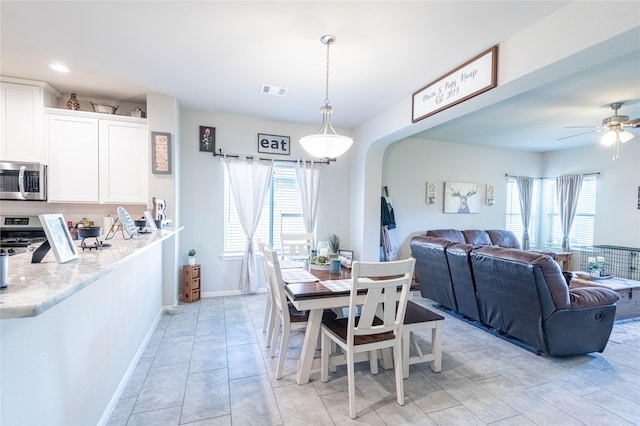 26019 Babe Ruth Dr, Splendora, TX 77372 - dining space featuring arched walkways, plenty of natural light, a ceiling fan, and baseboards