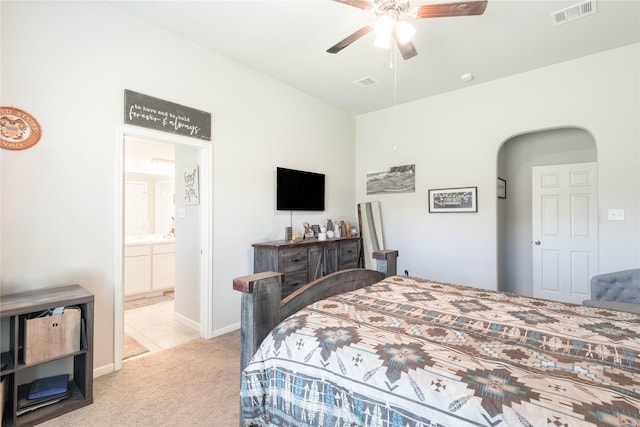 26019 Babe Ruth Dr, Splendora, TX 77372 - bedroom with light carpet, arched walkways, connected bathroom, ceiling fan, and baseboards