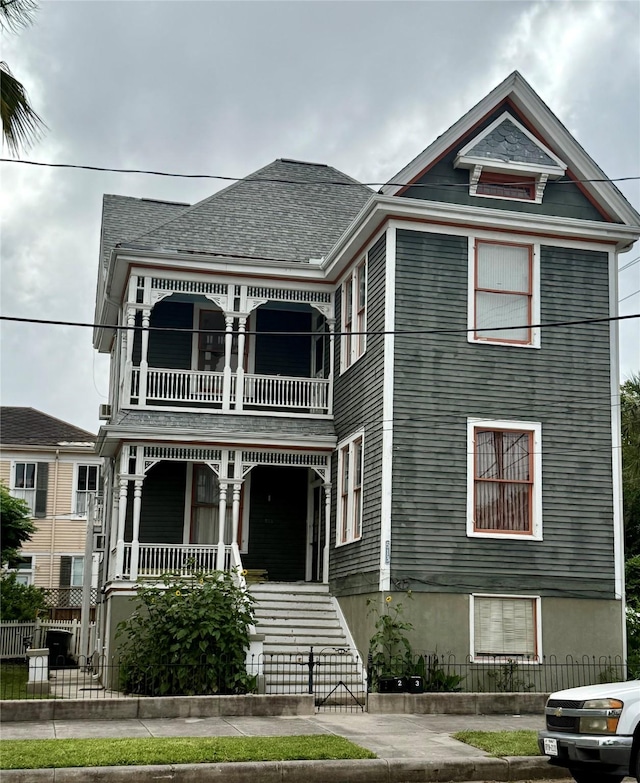 513 17th St, Galveston, TX 77550 - victorian-style house featuring a balcony, covered porch, and fence