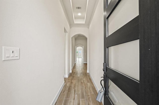 18511 Wolf Mountain Ln, Cypress, TX 77433 - corridor featuring arched walkways, light wood-style floors, and baseboards