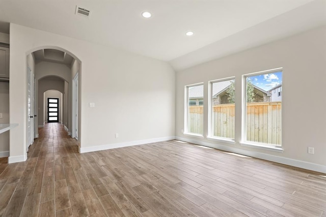 18511 Wolf Mountain Ln, Cypress, TX 77433 - spare room with light wood-style floors, arched walkways, baseboards, recessed lighting, and vaulted ceiling