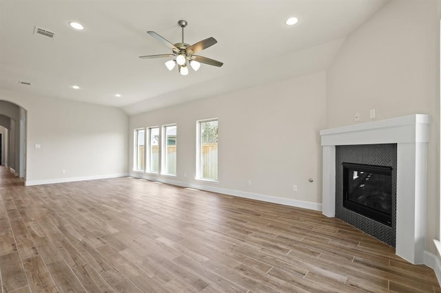 18511 Wolf Mountain Ln, Cypress, TX 77433 - unfurnished living room featuring a ceiling fan, wood finished floors, arched walkways, a fireplace, and recessed lighting
