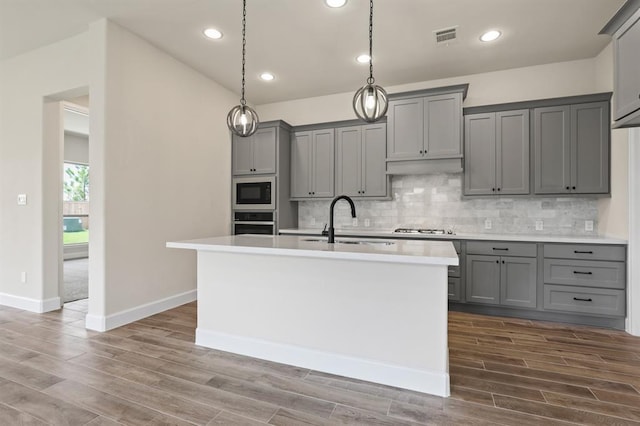 18511 Wolf Mountain Ln, Cypress, TX 77433 - kitchen with gray cabinets, a sink, dark wood-style flooring, light countertops, and recessed lighting