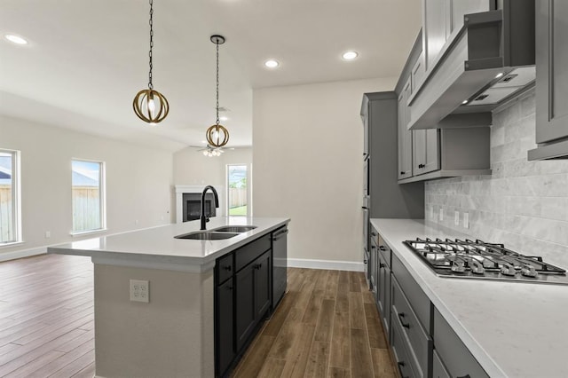 18511 Wolf Mountain Ln, Cypress, TX 77433 - kitchen with a sink, appliances with stainless steel finishes, exhaust hood, dark wood-style flooring, and healthy amount of natural light