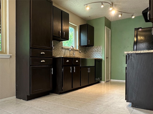 1405 Alma Dr, Austin, TX 78753 - kitchen featuring tasteful backsplash, light tile patterned floors, a textured ceiling, and stone counters