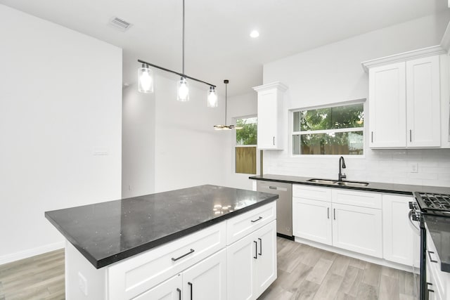 3309 Shelby Cir, Houston, TX 77051 - kitchen featuring a sink, stainless steel appliances, decorative backsplash, light wood-type flooring, and white cabinets