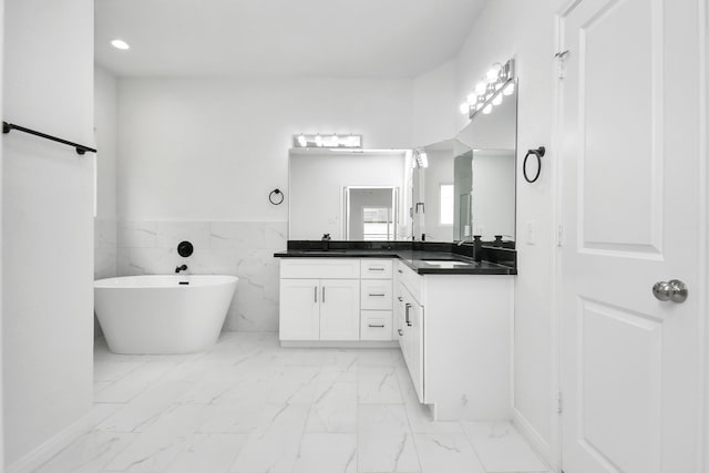 3309 Shelby Cir, Houston, TX 77051 - bathroom featuring marble finish flooring, a freestanding bath, vanity, recessed lighting, and wainscoting