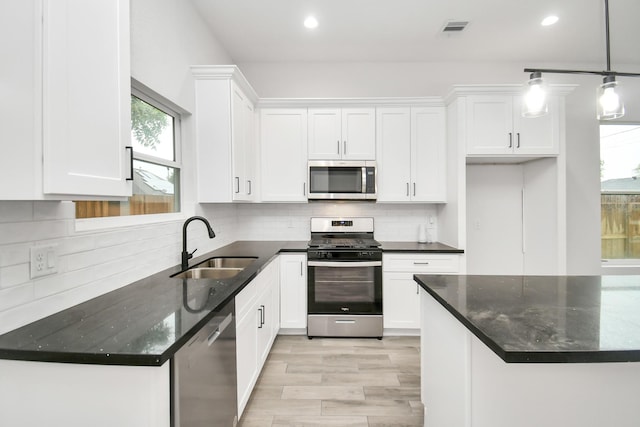 3309 Shelby Cir, Houston, TX 77051 - kitchen with stainless steel appliances, a sink, plenty of natural light, white cabinetry, and recessed lighting