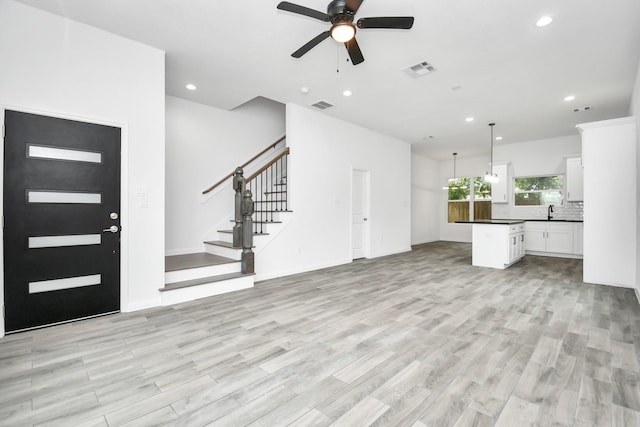 3309 Shelby Cir, Houston, TX 77051 - unfurnished living room featuring a ceiling fan, recessed lighting, light wood finished floors, stairway, and a sink