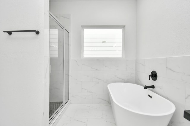 3309 Shelby Cir, Houston, TX 77051 - bathroom with marble look tiles, a shower stall, and a freestanding tub