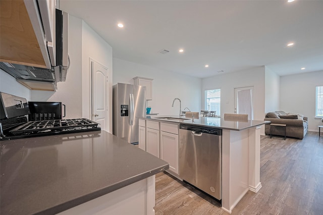 40434 Basalt Elm Rd, Magnolia, TX 77354 - kitchen with stainless steel appliances, a sink, light wood-type flooring, white cabinetry, and recessed lighting