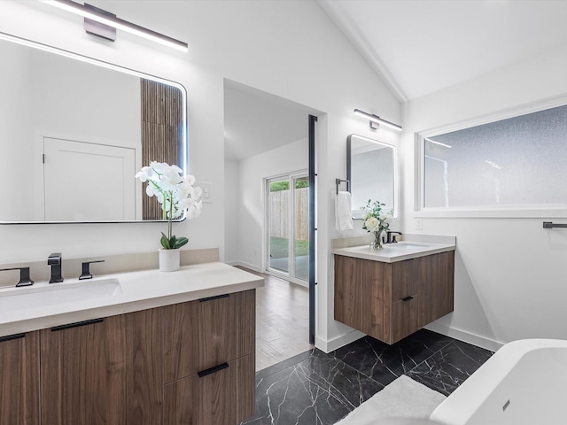 1208 Curtin St, Houston, TX 77018 - bathroom featuring lofted ceiling, two vanities, marble finish floors, and baseboards