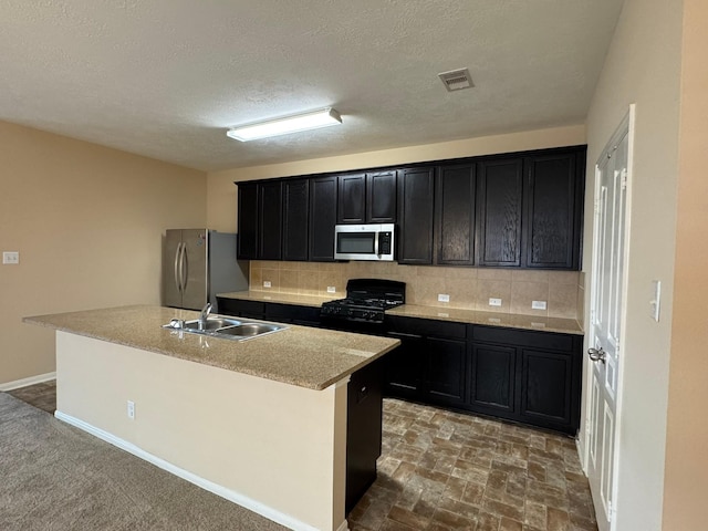 42 Blisten Spring Dr, Manvel, TX 77578 - kitchen with appliances with stainless steel finishes, a sink, dark cabinetry, backsplash, and a textured ceiling