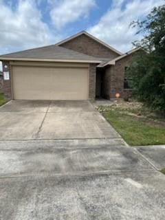 single story home featuring driveway, a garage, and brick siding