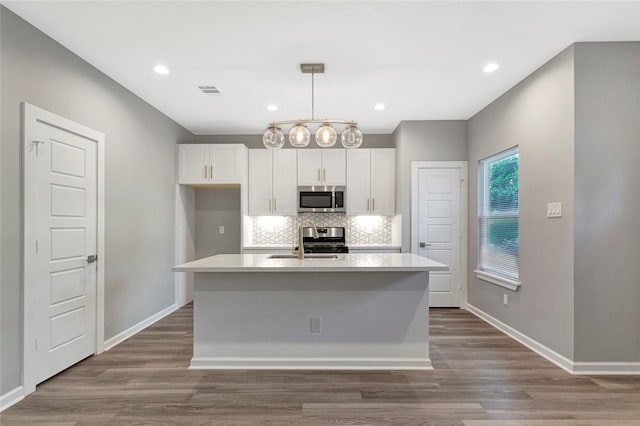6814 Dumble St, Houston, TX 77021 - kitchen with appliances with stainless steel finishes, white cabinets, a sink, light countertops, and backsplash