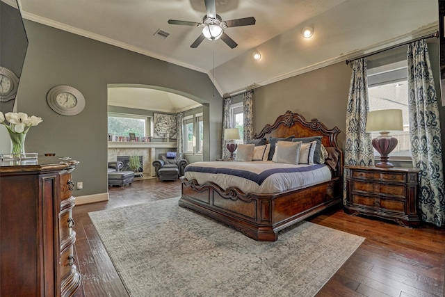 21514 Fairhaven Creek Dr, Cypress, TX 77433 - bedroom with arched walkways, dark wood-style floors, crown molding, a fireplace, and baseboards