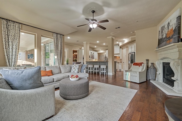 21514 Fairhaven Creek Dr, Cypress, TX 77433 - living area featuring ceiling fan, dark wood-style flooring, decorative columns, a glass covered fireplace, and recessed lighting