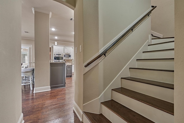 21514 Fairhaven Creek Dr, Cypress, TX 77433 - stairway featuring wood finished floors, crown molding, a textured wall, baseboards, and arched walkways