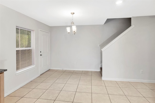 4079 Frontier Rd, Willis, TX 77378 - unfurnished dining area with a chandelier, light tile patterned flooring, and baseboards