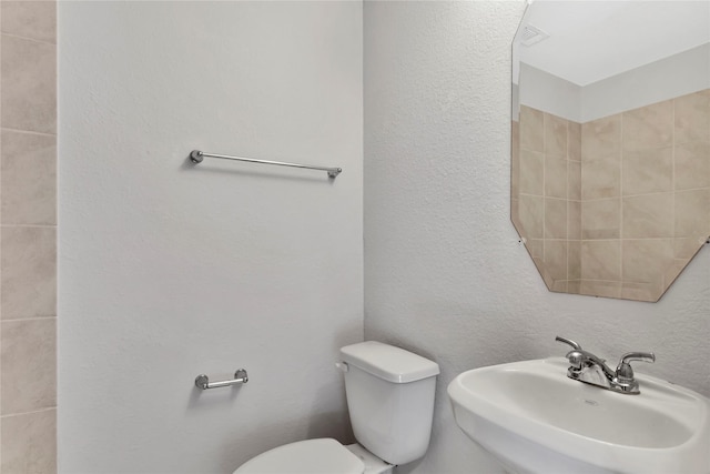 4079 Frontier Rd, Willis, TX 77378 - bathroom with a sink, toilet, and a textured wall