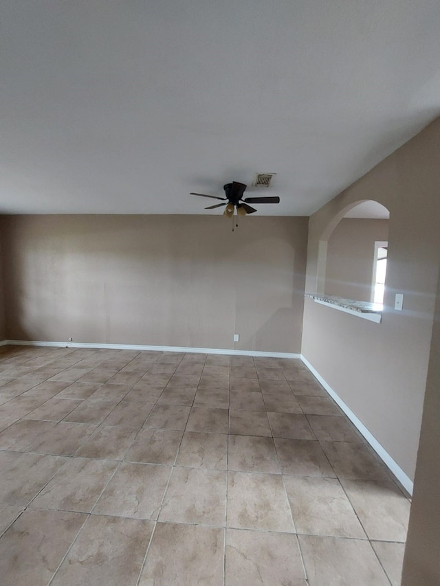 1707 W 7th St, Freeport, TX 77541 - empty room with ceiling fan, tile patterned floors, baseboards, and arched walkways