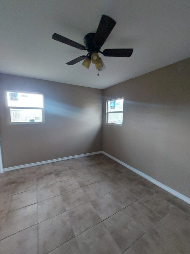 1707 W 7th St, Freeport, TX 77541 - empty room featuring a ceiling fan, baseboards, and tile patterned flooring