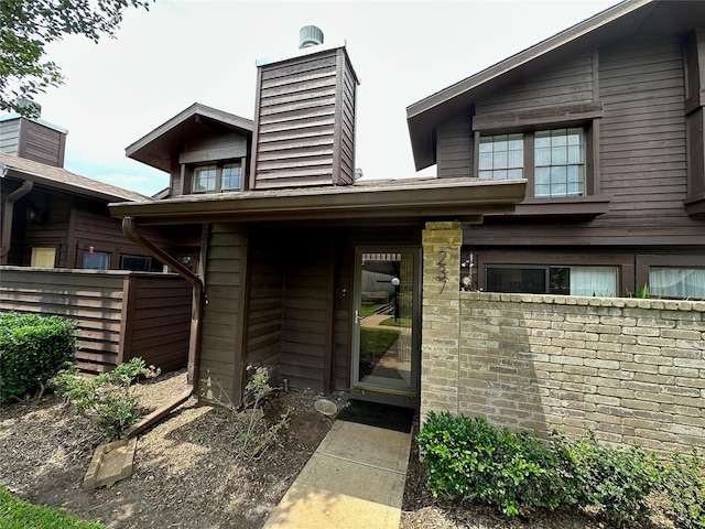 2611 Grants Lake Blvd Unit 237, Sugar Land, TX 77479 - view of exterior entry featuring fence and a chimney