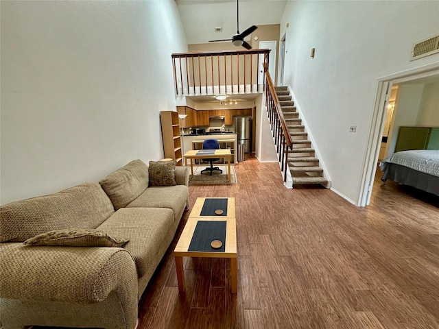 2611 Grants Lake Blvd Unit 237, Sugar Land, TX 77479 - living room with a towering ceiling, stairs, wood finished floors, a ceiling fan, and baseboards