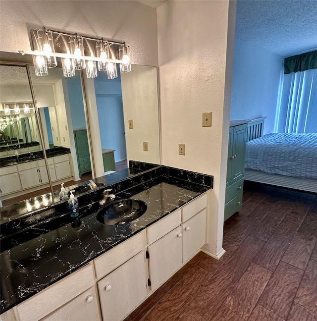 2611 Grants Lake Blvd Unit 237, Sugar Land, TX 77479 - bathroom featuring a sink, a textured wall, a textured ceiling, and wood finished floors