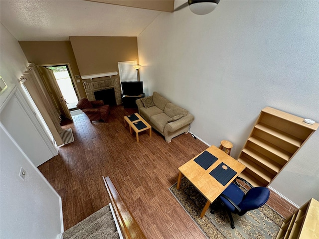 2611 Grants Lake Blvd Unit 237, Sugar Land, TX 77479 - living room featuring wood finished floors, a brick fireplace, and lofted ceiling