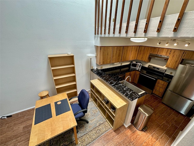 2611 Grants Lake Blvd Unit 237, Sugar Land, TX 77479 - kitchen featuring stainless steel appliances, dark countertops, brown cabinets, dark wood-style flooring, and under cabinet range hood