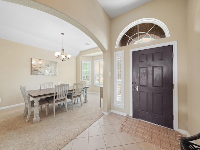 29954 Spring Creek Ln, Brookshire, TX 77423 - foyer entrance with light carpet, a chandelier, arched walkways, baseboards, and light tile patterned floors