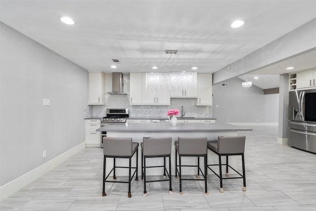 7727 Barberton Dr, Houston, TX 77036 - kitchen featuring stainless steel appliances, wall chimney range hood, tasteful backsplash, baseboards, and a breakfast bar area