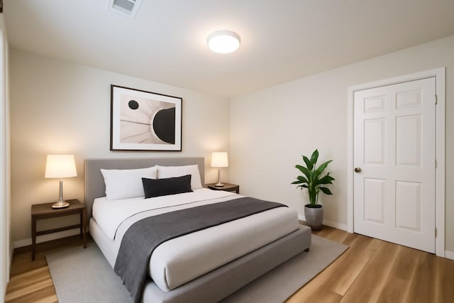 bedroom with light wood finished floors and baseboards