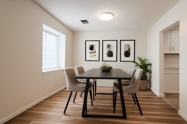 dining area featuring light wood-style flooring and baseboards