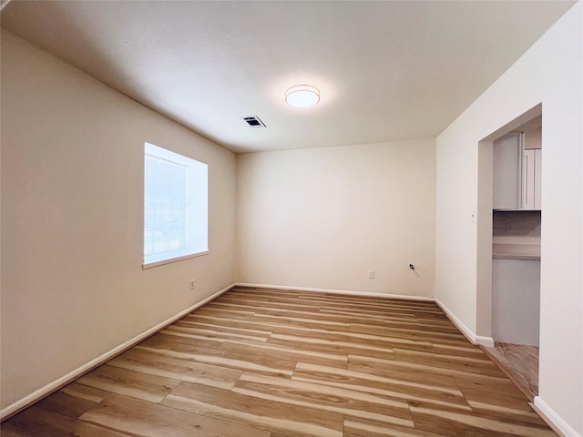 spare room featuring light wood finished floors and baseboards