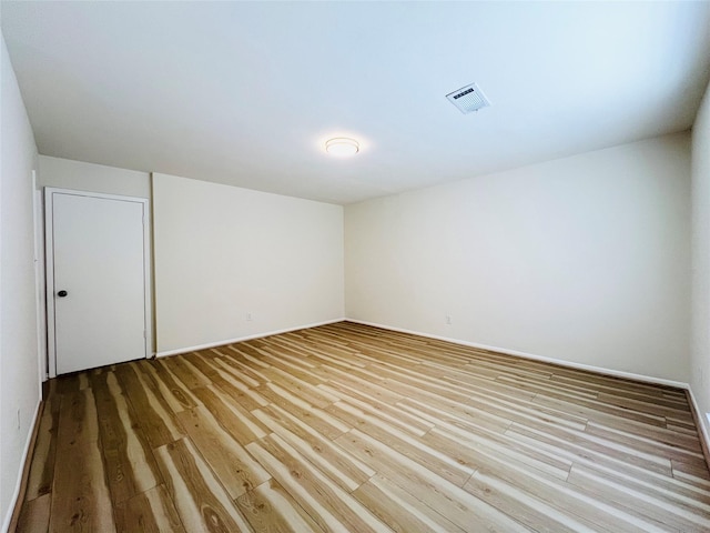 spare room with wood finished floors and baseboards