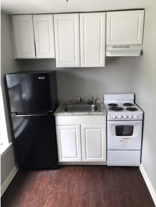511 W Cleveland St, Alvin, TX 77511 - kitchen with electric range, freestanding refrigerator, range hood, a sink, and dark wood-style floors