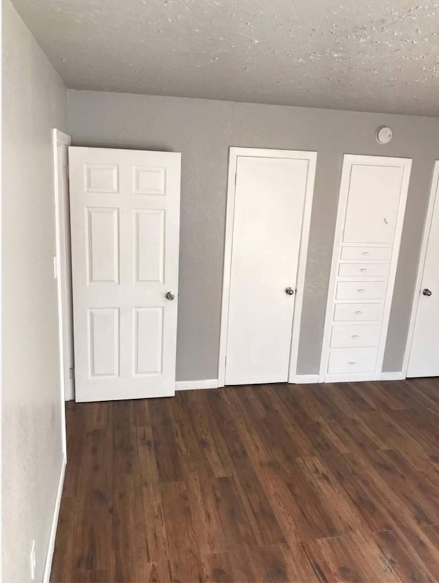 511 W Cleveland St, Alvin, TX 77511 - unfurnished bedroom with wood finished floors, baseboards, and a textured ceiling